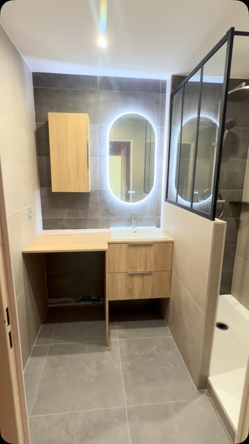 Salle de bain avec meuble en bois et miroir lumineux